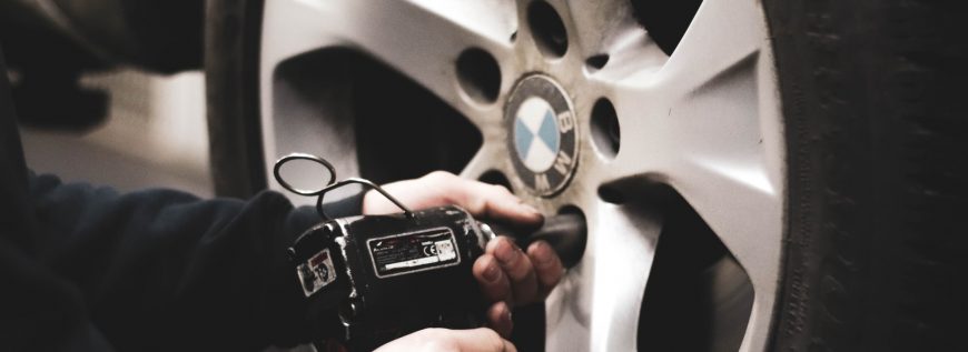 man servicing the wheels of a bmw
